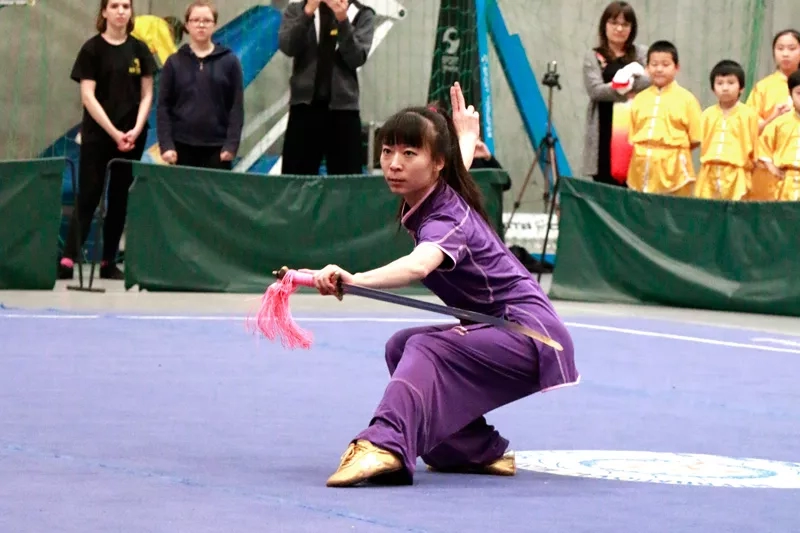 Kobieta o azjatyckiej urodzie, ubrana w fioletowe kimono przygotowuje się do ataku. W lewej dłoni trzyma miecz, ostrzem skierowany w prawą stronę. Lewa dłoń jest wystawiona do przodu, podczas gdy prawa wystawiona lekko do góry. Ramiona są rozłożone. Kobieta jest sklupiona.